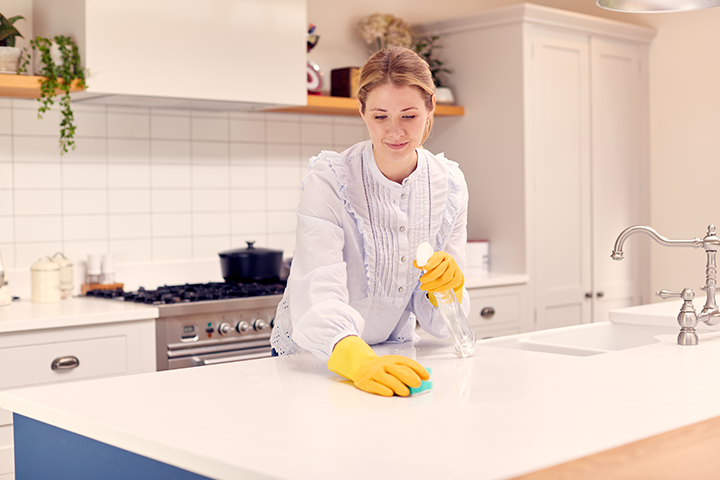 Woman cleans countertops as part of effort to prepare for cockroach control treatment